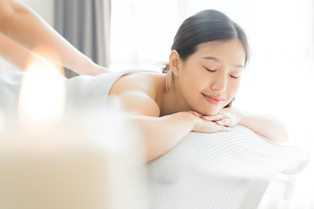Young asian woman in spa salon getting massage.