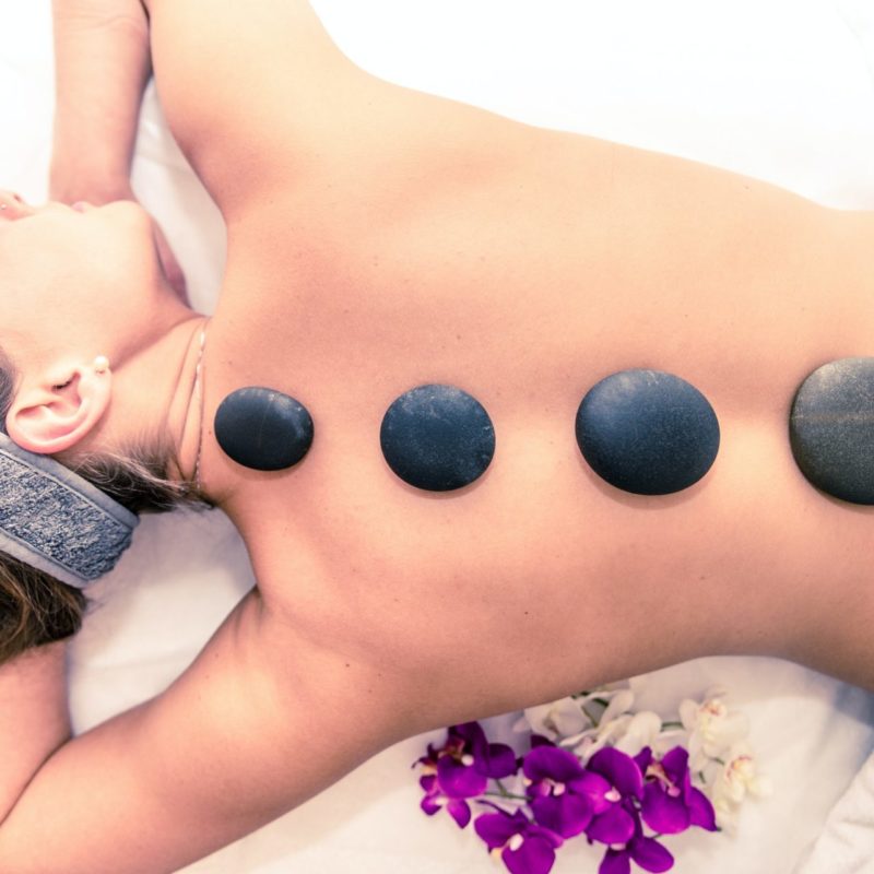 Woman having massage with hot stones